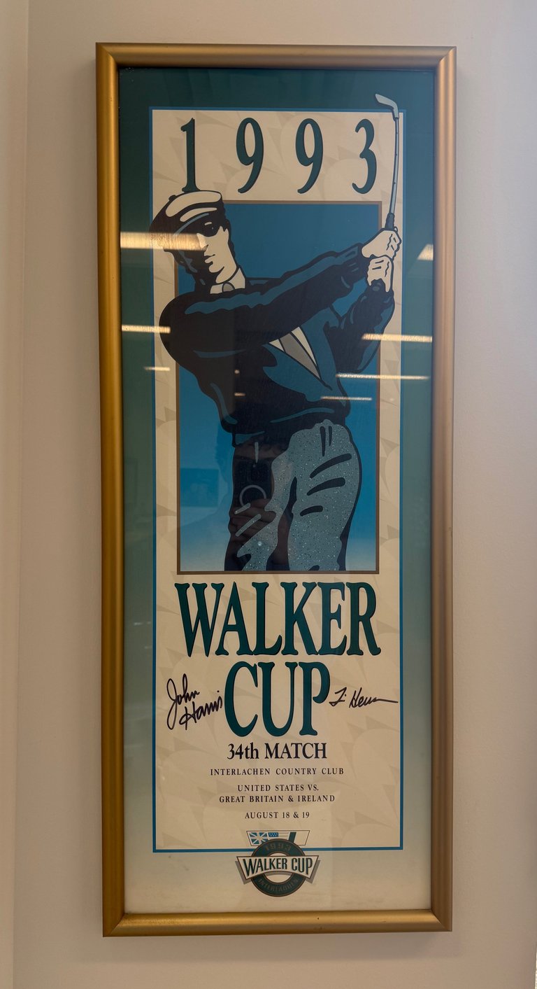 Framed 1993 Walker Cup golf tournament poster featuring golfer illustration, signed, displayed on wall