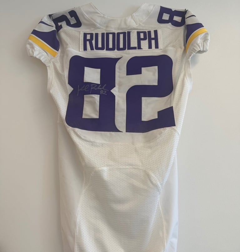 White football jersey number 82 with Rudolph name and purple trim, displayed on a hanger